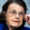 Sen. Dianne Feinstein rests her head on her hand while listening during a hearing.