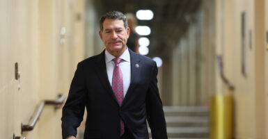 Rep. Mark Green, Rep. Tenn., walks, in a suit, down a hallway in the Capitol.