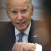 President Joe Biden gestures in a suit with an American flag pin