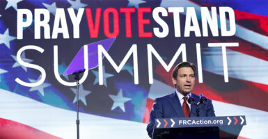 Gov. Ron DeSantis speaks at a podium with the Pray Vote Stand Summit sign behind