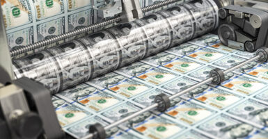 Hundred dollar bills roll off of a printing press