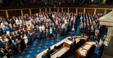 Members of Congress stand and clap on the House floor.