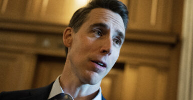 Josh Hawley in the halls of Congress wearing a collared shirt