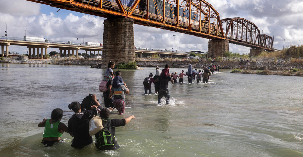 A group of illegal aliens walk through the Rio Grande to cross the U.S. border into Texas.
