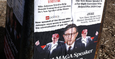 Posters outside in Washington, D.C., cite alarmist headlines about House Speaker Mike Johnson