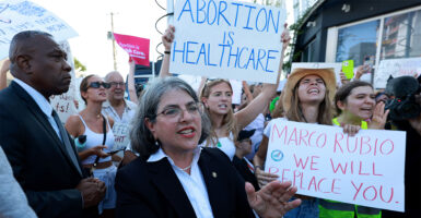 People protest the Supreme Court's decision overturning Roe v. Wade with signs like "Abortion is Healthcare"