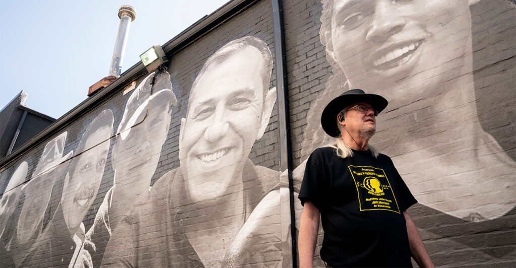 A man walks past a mural depicting U.S. citizens who are being wrongfully detained or held hostage abroad
