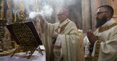 Catholic priest offers incense smoke in a church