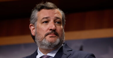 Ted Cruz carries a serious face in a gray suit