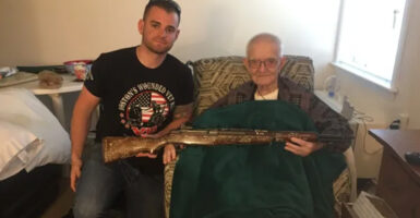 Andrew Biggio, author of “The Rifle 2: Back to the Battlefield,” and WWII veteran Carl DiCicco pose for a photo with a M1 Garand rifle.
