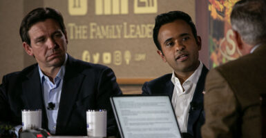 Ron DeSantis and Vivek Ramaswamy in suits without ties in front of a "The Family Leader" logo