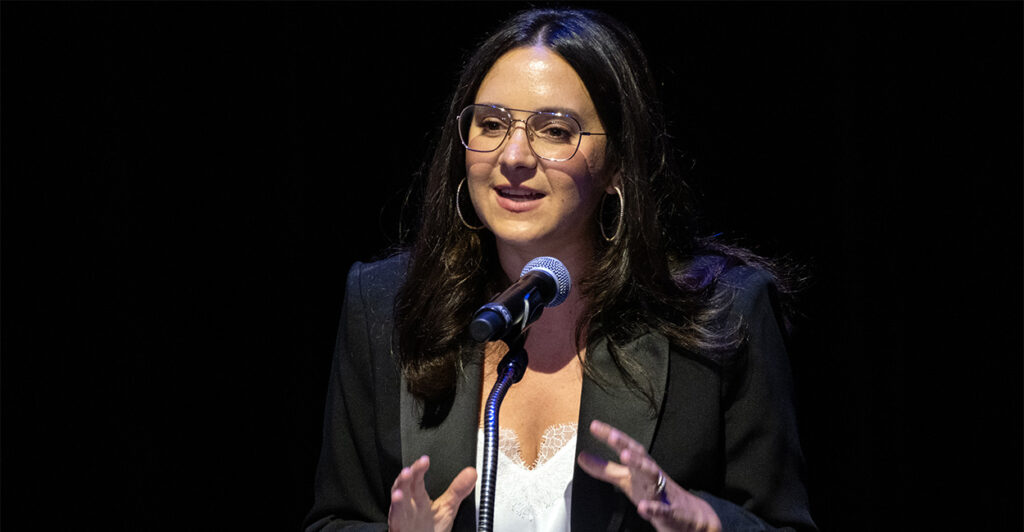 Bari Weiss speaking at a microphone