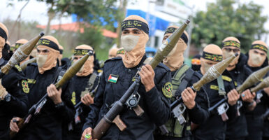 Soldiers with Palestinian Islamic Jihad wear Arabic head coverings and carry rocket launchers.