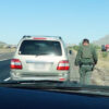 Deputy Sheriff Mark Terry walks up to an SUV he pulled over in the Arizona desert.