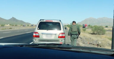 Deputy Sheriff Mark Terry walks up to an SUV he pulled over in the Arizona desert.