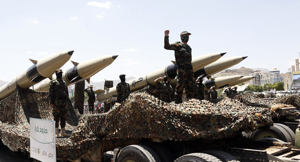 Houthi leaders stand with ballistic missiles in a parade in Sanaa.