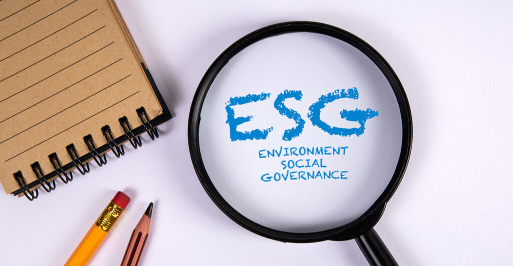 Magnifying glass on office desk highlighting the words “ESG – Environment, Social, Governance”