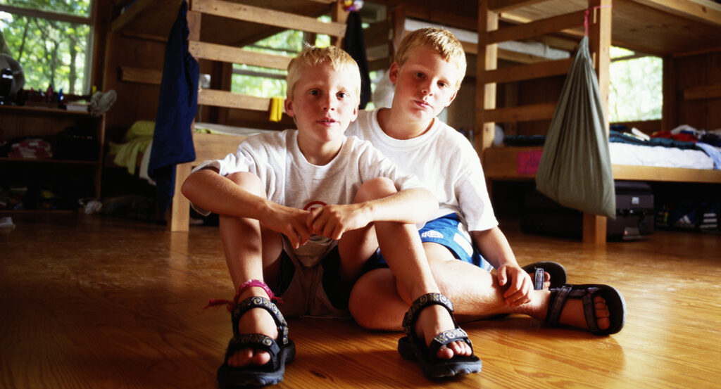 Two young blond boys in a room with bunk beds