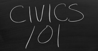 "Civics 101" is seen written on a chalk board.