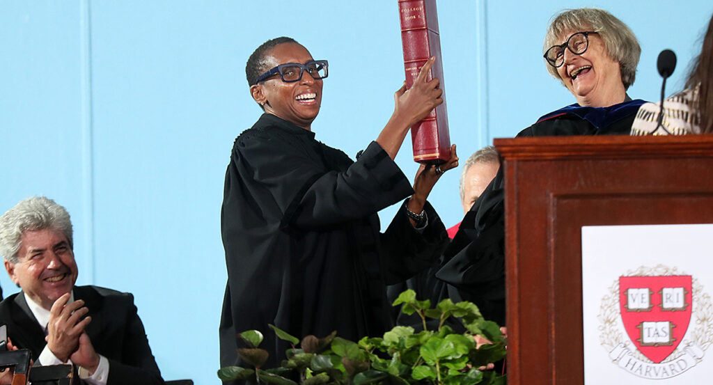 Harvard President Claudine Gay holds a book in black robes