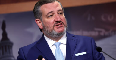 Sen. Ted Cruz talks at a press conference in a suit.