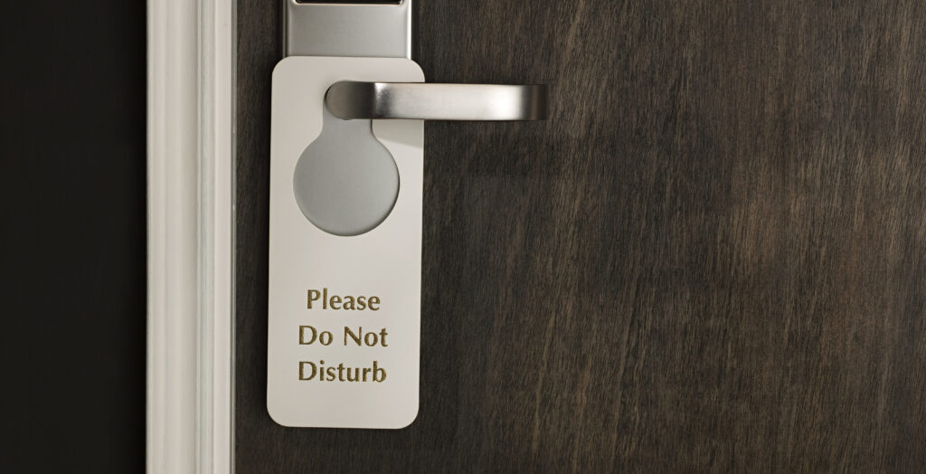 hotel door handle with sign reading "Do Not Disturb"