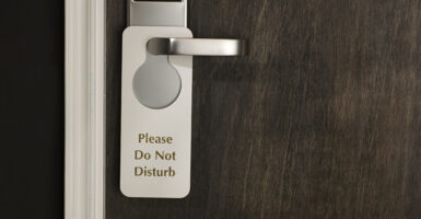 hotel door handle with sign reading 