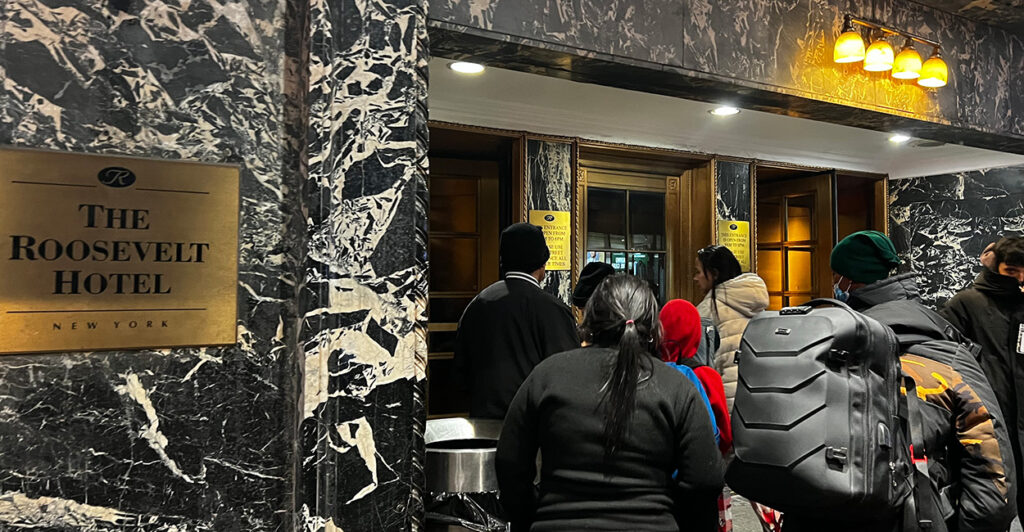 Several illegal aliens stand outside the entrance to the Roosevelt Hotel in New York City.