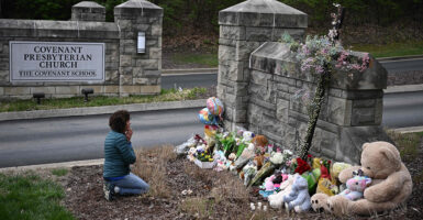 Woman prays in front of a memorial for the victims of the Nashville shooting at Covenant School