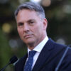 Australian Defence Minister Richard Marles Speaks at a microphone outdoors