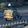 a truck drives with an israel flag