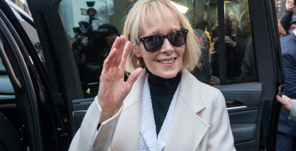 E. Jean Carroll waves in a suit and dark sunglasses