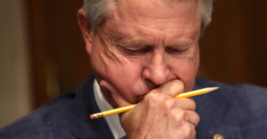 Sen. Roger Marshall, R-Kan., looks down with a pencil in his hand.