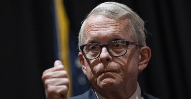 Ohio Gov. Mike DeWine purses his lips in a suit while wearing glasses