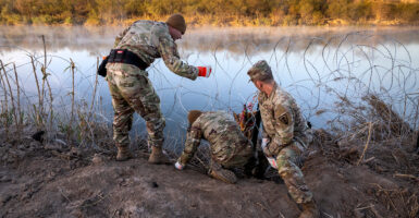 Three Texas National Guard soldiers install razor wire along the southern border.