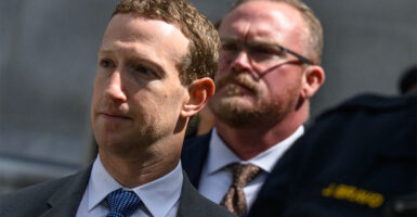 Mark Zuckerberg in a suit walking outside a government building with others
