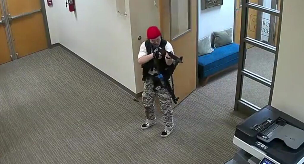 Audrey Hale in camouflage pants levels a gun at a printer in Nashville's Covenant School