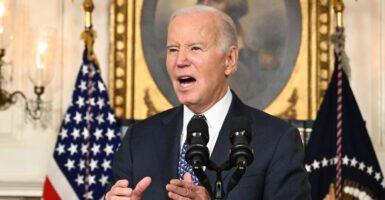 President Joe Biden in a suit speaking at a podium in the White House