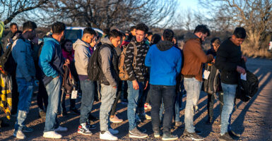 Illegal alien males stand in a line outside after crossing the border.