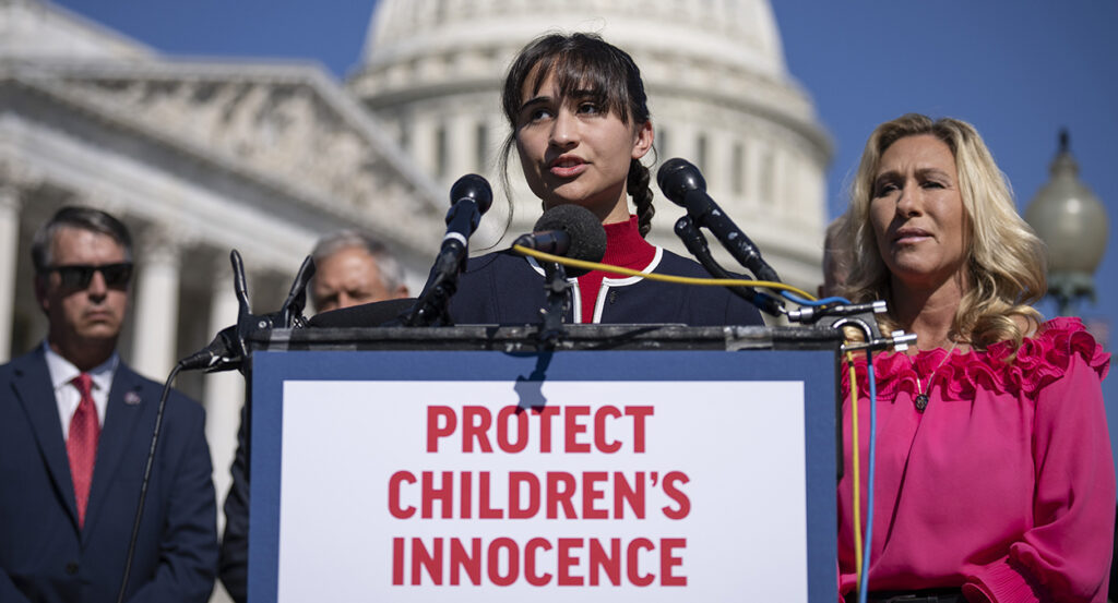 Detransitioner Chloe Cole stands in front of the Capitol behind a sign reading, "Protect Children's Innocence."
