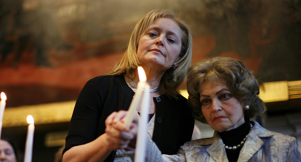 Katrina Lantos Swett stands with her mother, lighting a candle in memory of her late father, Tom Lantos.