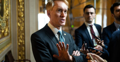 Sen. James Lankford, R-Okla., stands in a suit talking to press.