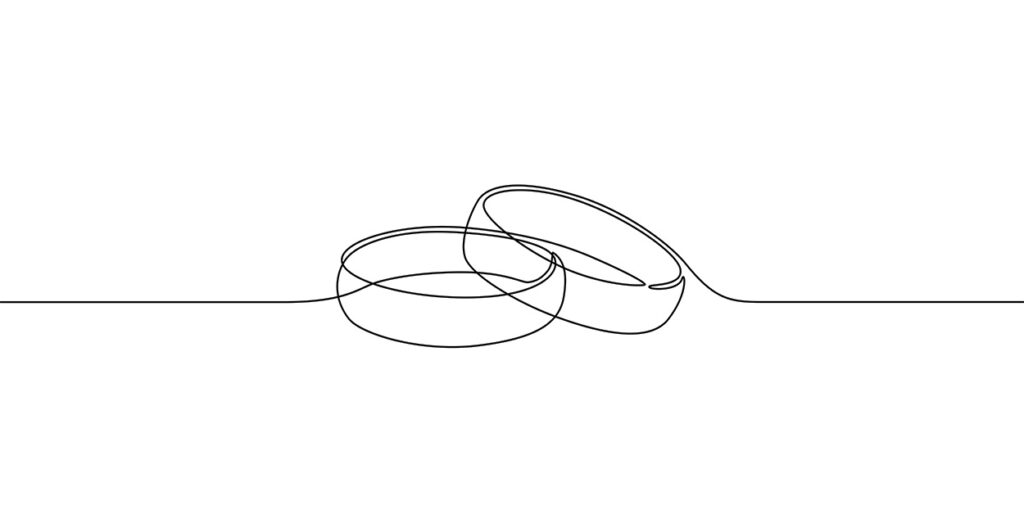 A sketch of two wedding bands is seen on a white paper.