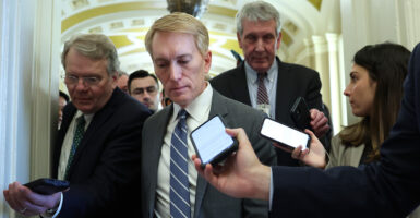 Reports hold phone up to Sen. James Lankford, R-Okla., as they ask him question while he walks through the halls of the Capitol.