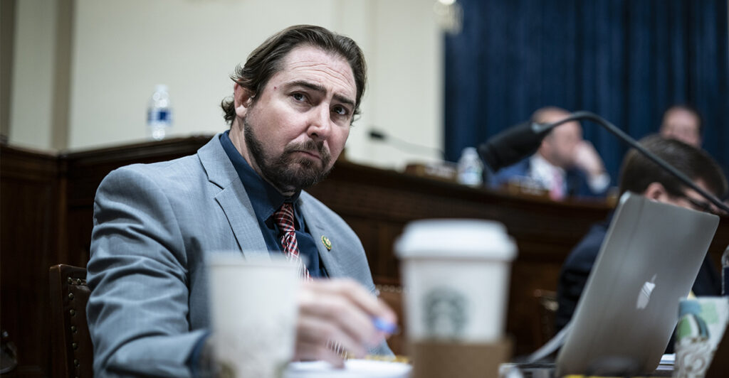 Rep. Eli Crane in a suit sitting at the dais in a congressional hearing room