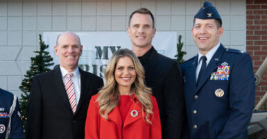 Bill Abbott, Candace Cameron Bure, Gabriel Hogan, and Colonel Brandon Sokora in suits, uniforms, and a red dress
