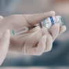 A doctor uses a syringe to prepare a COVID-19 vaccine.