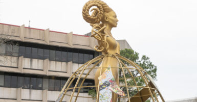 A golden, female-looking statue with braided horns overlooks the University of Houston campus.
