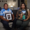Emilio Tambunga and his daughter Elisa Tambunga sit on a couch holding pictures of their family members killed in a car crash with a human smuggler.