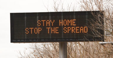 An electronic sign on the highway with the message "stay home, stop the spread"